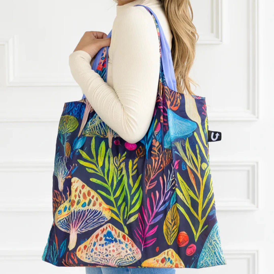 A colorful tote bag with a psychedelic mushroom and plant pattern. The bag has a dark blue background with bright, vibrant colors.
