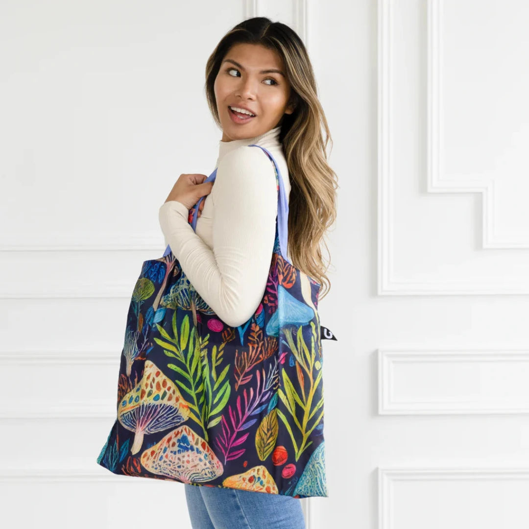 A colorful tote bag with a psychedelic mushroom and plant pattern. The bag has a dark blue background with bright, vibrant colors.