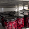 A jar of Maraschino Cherries from Top Shelf Preserves. The jar is filled with red cherries and has a black label with white text. The label includes the product name, 
