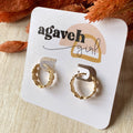 Gold hoop earrings on a 'agaveh girl' branded card with dried orange flowers in the background.
