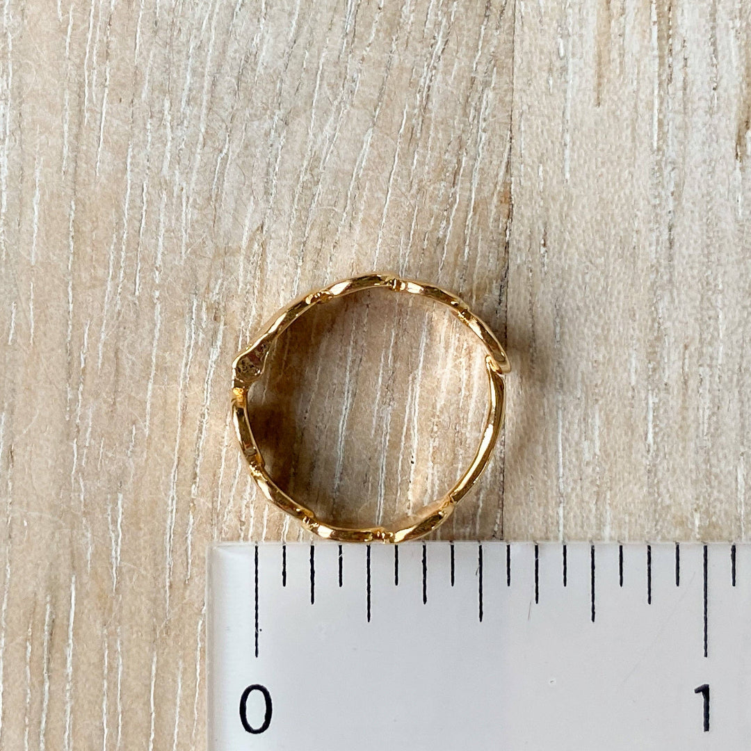 Gold ring on a wooden surface with a ruler for scale