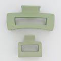 Two light green hair clips on a white background