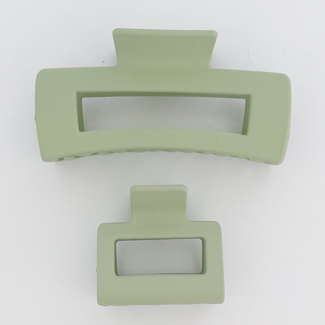 Two light green hair clips on a white background