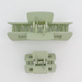Two light green hair clamps on a white background