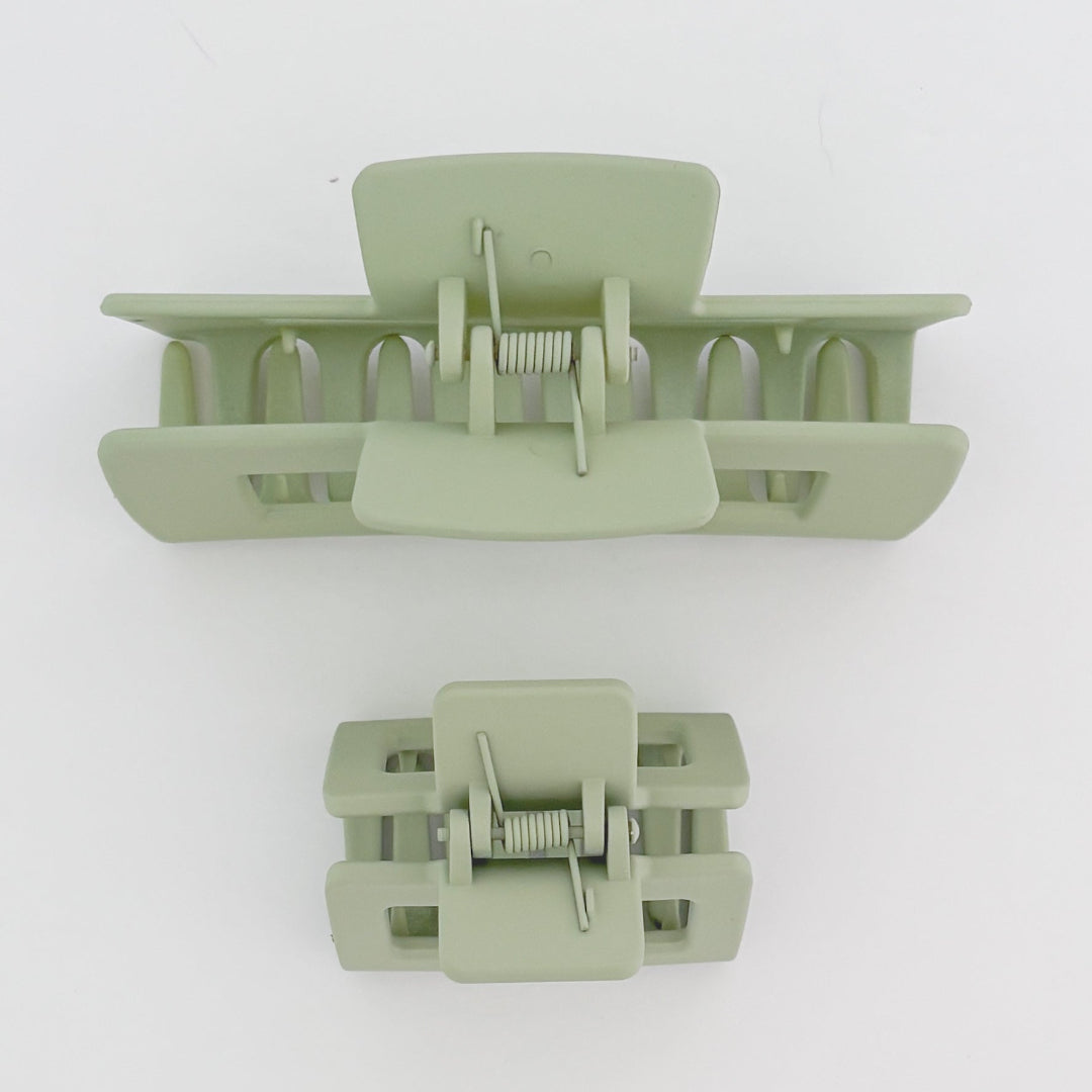 Two light green hair clamps on a white background