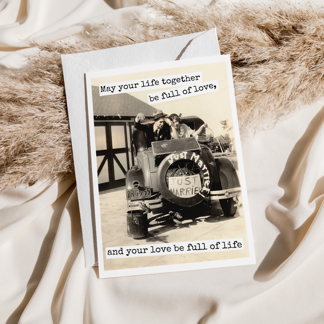 Greeting card with vintage car and couple photo, text 'May your life together be full of love' on a textured surface.