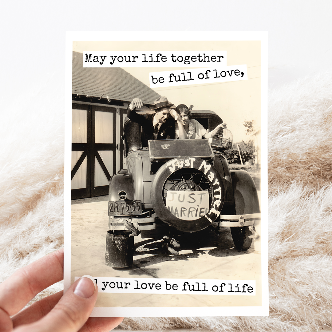 Vintage-style card with a couple in a car labeled 'Just Married' and text about love and life.