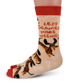 Sock with dog illustrations and text 'LESS MEANIES MORE WEE尼ES' on a beige background