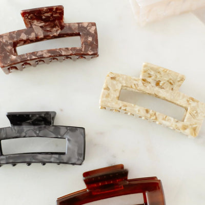 Set of marble-patterned hair clips on a white surface