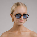 Woman wearing sunglasses with a plain background