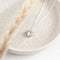 A silver plated locket pendant on a delicate silver chain.