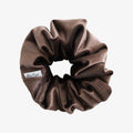 Brown scrunchie with a visible brand label on a white background