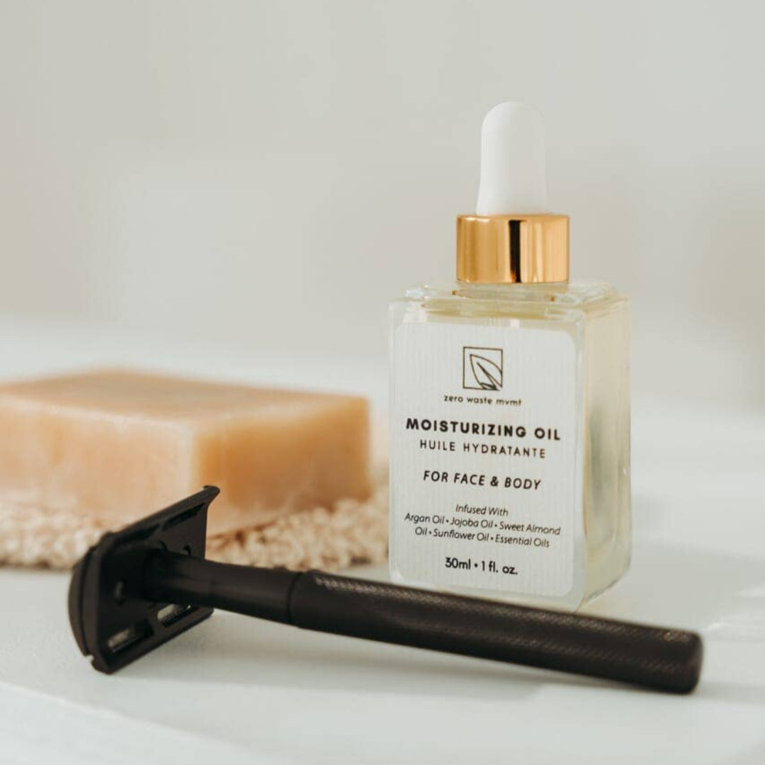 Moisturizing oil bottle with a razor on a light background