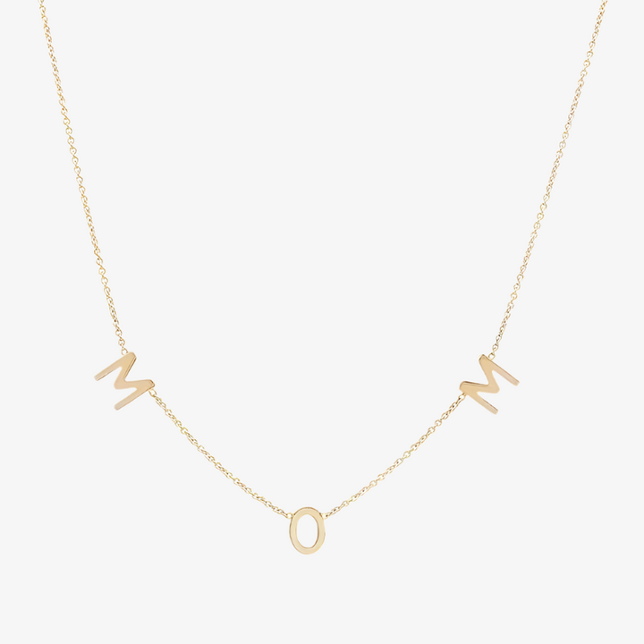 A delicate gold-filled necklace spelling out 'MOM' with individual letter charms evenly spaced along a fine chain, displayed on a white background. This heartfelt necklace is available in Ottawa, Ontario, Canada.