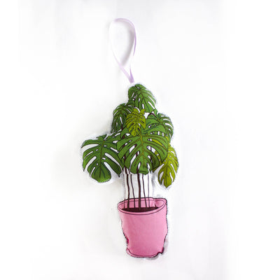 Plush toy of a potted plant with green leaves and a pink pot on a white background