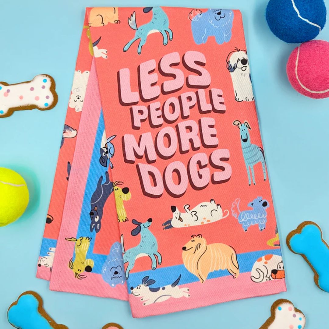 Two pink books with dog illustrations and 'LESS PEOPLE MORE DOGS' text on a blue background with dog toys.