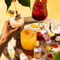 Assorted cocktails on a tray with 'Pina Colada' and 'San Juan Salsa' bottles.