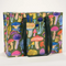 A large, reusable tote bag with a mushroom pattern. The bag is olive green with black handles. It is covered in a variety of colorful mushrooms in different shapes and sizes.