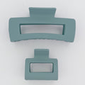 Two teal hair clips on a white background