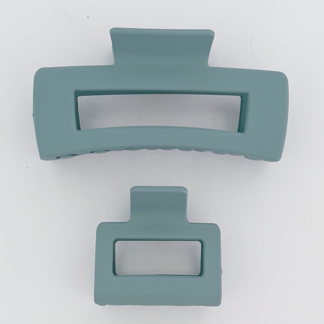 Two teal hair clips on a white background