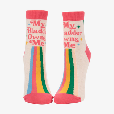 A pair of white ankle socks with a playful design. The socks have a rainbow stripe pattern and the text 