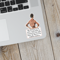 Laptop with a sticker of a person and text on a wooden surface