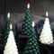 A green, beeswax candle shaped like a Christmas tree. The candle has detailed branches and a pointed top.