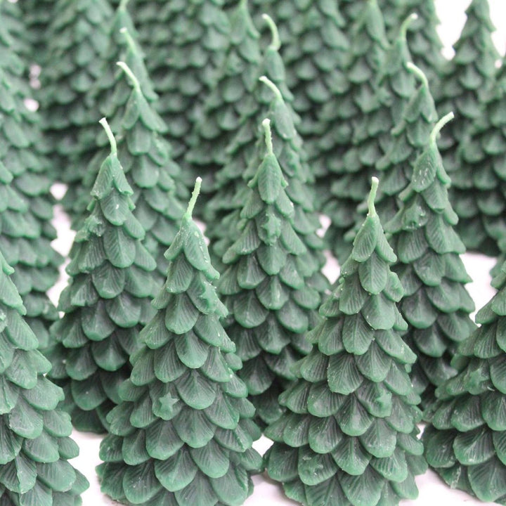 A green, beeswax candle shaped like a Christmas tree. The candle has detailed branches and a pointed top.