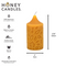 A yellow beeswax pillar candle with a leaf pattern. The candle has a label that says 