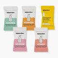 Five Nature Bee foaming hand soap tablet packets arranged on a white background, each in a different color: mint green, orange, yellow, pink, and peach.