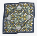 A navy blue bandana with a floral pattern in shades of green and yellow. The pattern features stylized flowers, leaves, and small dots.
