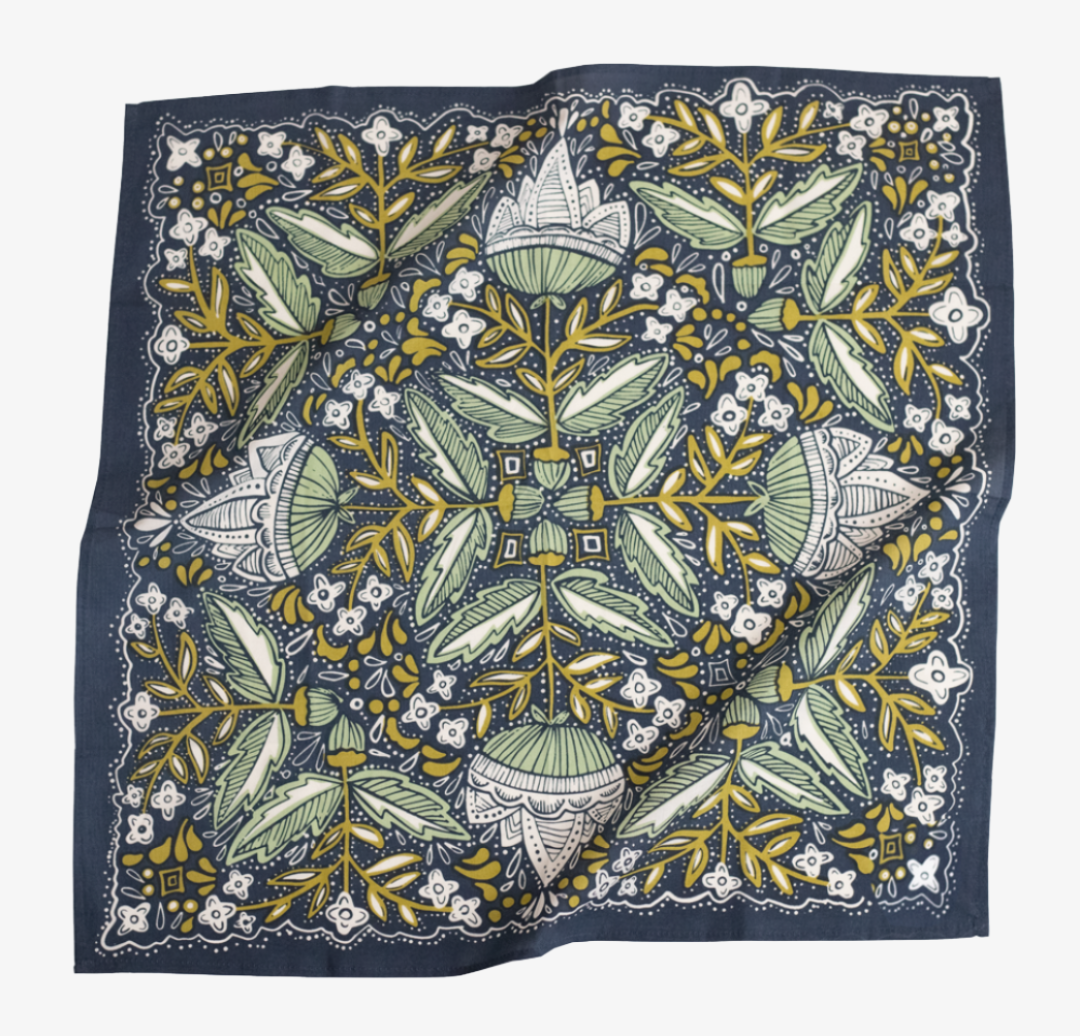 A navy blue bandana with a floral pattern in shades of green and yellow. The pattern features stylized flowers, leaves, and small dots.