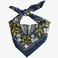 A navy blue bandana with a floral pattern in shades of green and yellow. The pattern features stylized flowers, leaves, and small dots.
