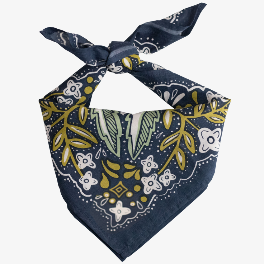 A navy blue bandana with a floral pattern in shades of green and yellow. The pattern features stylized flowers, leaves, and small dots.