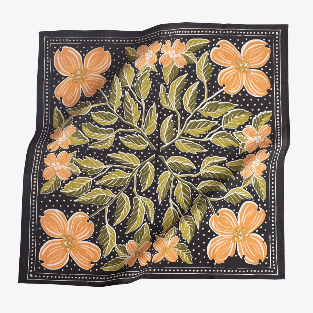 A black bandana with a floral pattern. The pattern features orange flowers and green leaves on a black background.