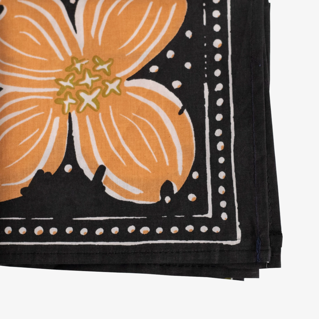 A black bandana with a floral pattern. The pattern features orange flowers and green leaves on a black background.