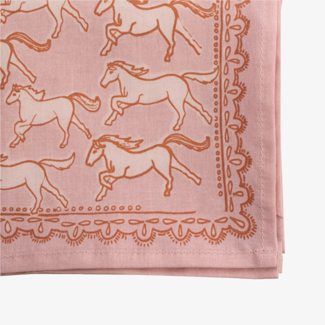 A pink bandana with a pattern of white galloping horses. The horses are evenly spaced and face in various directions.
