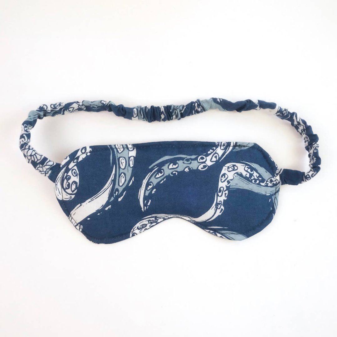 A blue sleep mask with an octopus pattern. The mask has an elastic band to fit around the head.