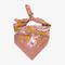 A pink bandana with a floral pattern. The pattern features white flowers with yellow centers and green leaves.