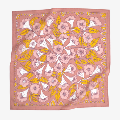 A pink bandana with a floral pattern. The pattern features white flowers with yellow centers and green leaves.