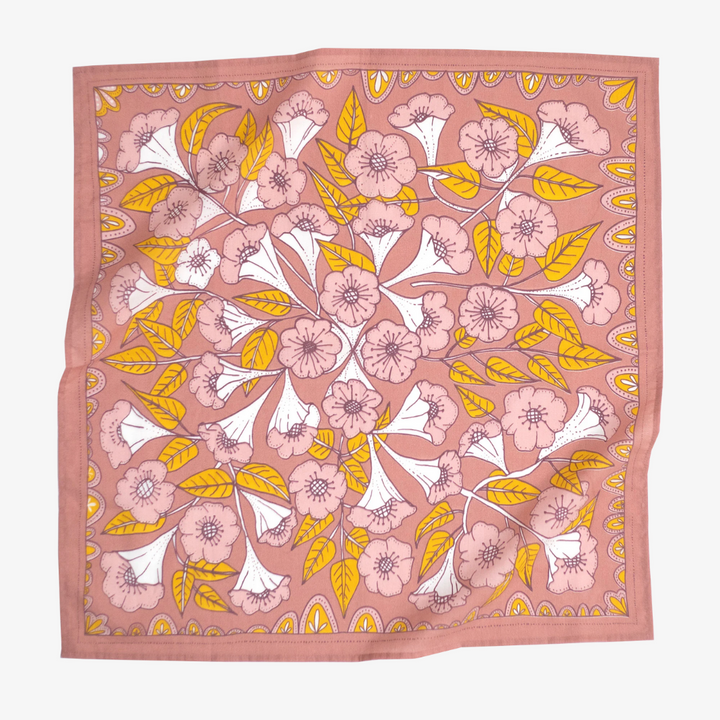 A pink bandana with a floral pattern. The pattern features white flowers with yellow centers and green leaves.