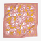 A pink bandana with a floral pattern. The pattern features white flowers with yellow centers and green leaves.
