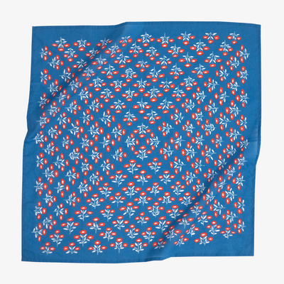 A blue bandana with a floral pattern. The pattern features small red flowers with white centers and white leaves.