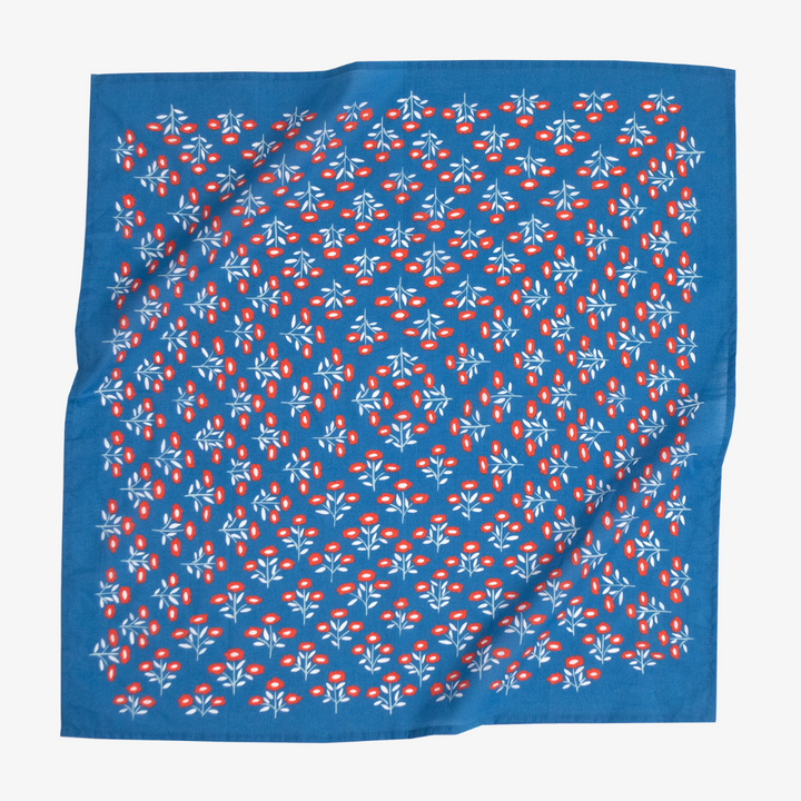 A blue bandana with a floral pattern. The pattern features small red flowers with white centers and white leaves.
