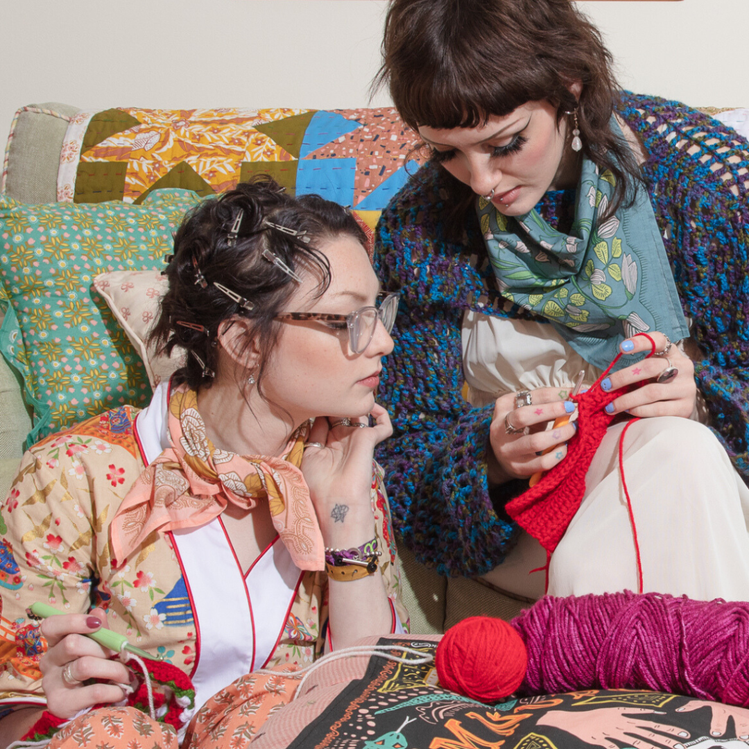 A blue bandana with a floral pattern. The pattern features white flowers with yellow centers and green leaves. The border of the bandana has a decorative, repeating pattern.