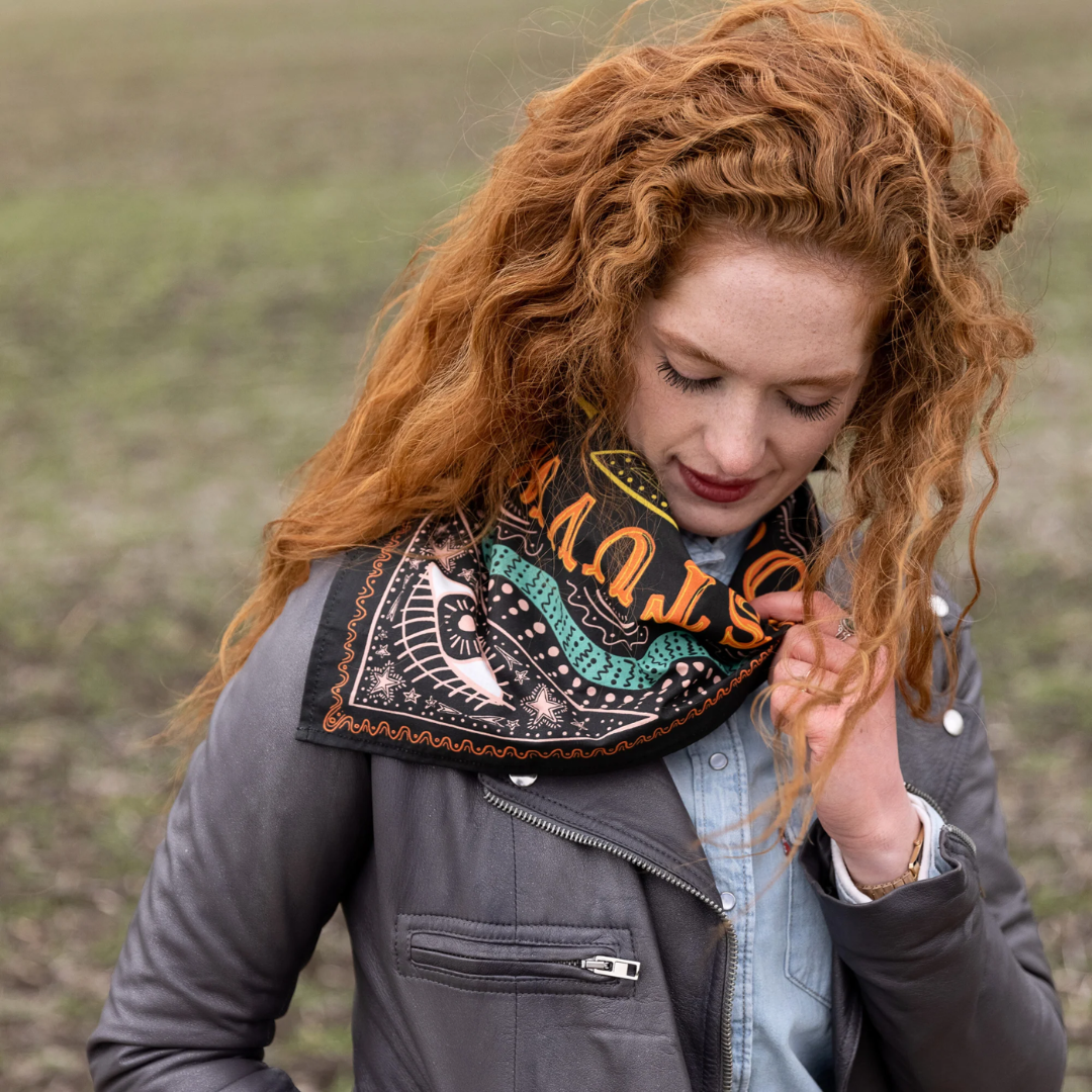 A black bandana with a mystical pattern. The pattern features a Ouija board design with hands pointing to letters and numbers, along with celestial symbols like moons and stars.