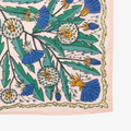 A pink bandana with a floral pattern. The pattern features blue and yellow dandelions with green leaves. The border of the bandana has a decorative, repeating pattern.