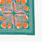 A green bandana with a floral pattern. The pattern features orange and pink flowers with green leaves. The border of the bandana has a decorative, repeating pattern.