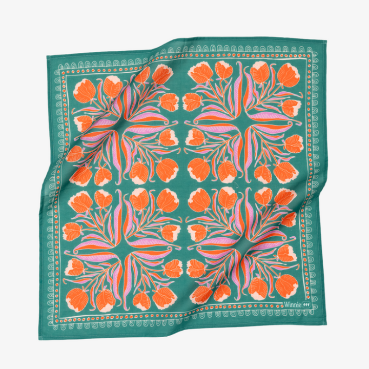 A green bandana with a floral pattern. The pattern features orange and pink flowers with green leaves. The border of the bandana has a decorative, repeating pattern.