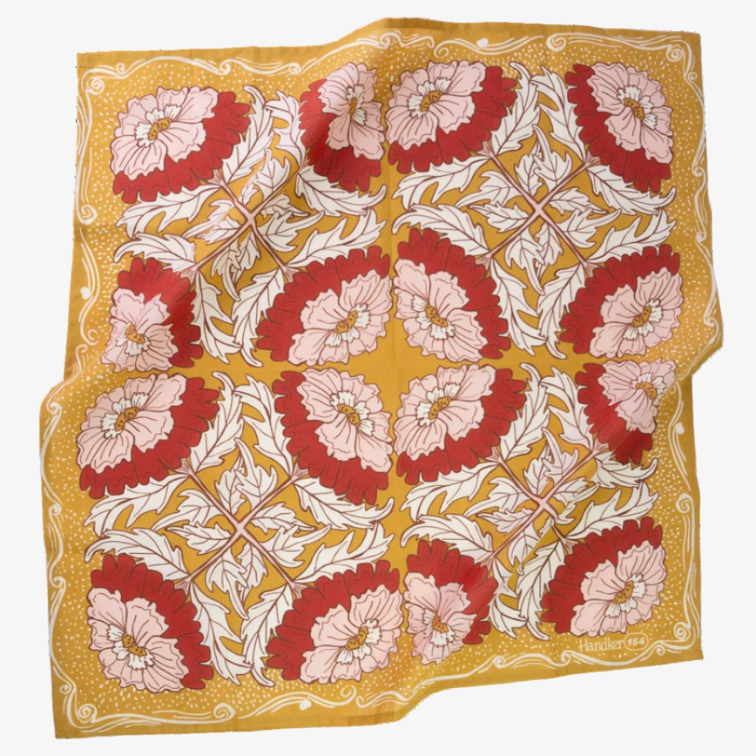 Floral patterned fabric with red, pink, and white flowers on a yellow background